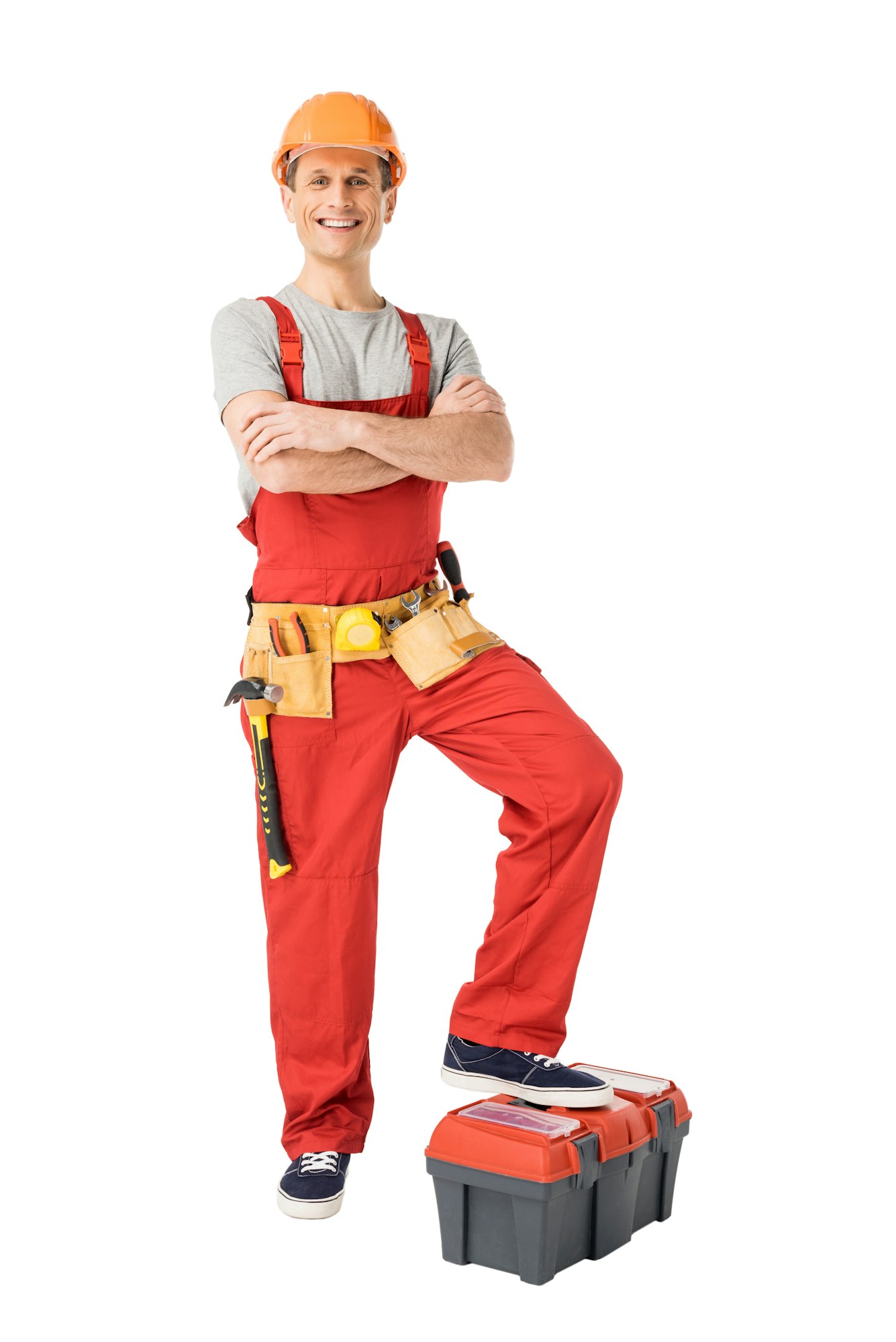 Builder with tools in belt standing with folded arms isolated on white